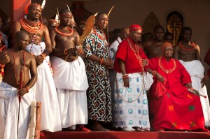 The Oba (King) of the Benin Royal Kingdom in Nigeria is seated beside his Chief Priest, (to his left) and his royal attendants, at the annual Igue Ceremony celebrating the power of the ancient kingdom and reaffirming its well-being and prosperity.